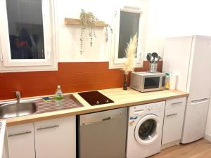 a kitchen with a sink and a washing machine at CAVALOC T2 terrasse vue colline in Cavalaire-sur-Mer