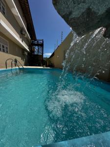 a pool with water shooting out of a rock at Orla Pousada & Café in Parnamirim