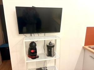 a flat screen tv hanging on a wall at CAVALOC T2 terrasse vue colline in Cavalaire-sur-Mer