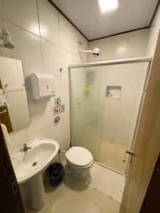 a bathroom with a shower and a toilet and a sink at Cosmopolitans Hostel in Ubatuba +29 photos