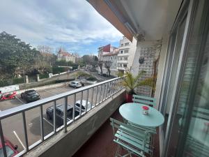 a balcony with a table and chairs and a view of a street at Studio Cosy Biarritz - classé 2 étoiles in Biarritz