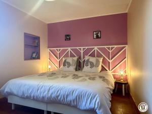 a bedroom with a large bed with purple walls at Le Refuge in Liernais