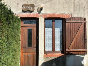 a door to a building with a sign on it at Le Refuge in Liernais