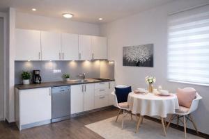 a kitchen with a table and a kitchen with white cabinets at Pula Paradise in Pula