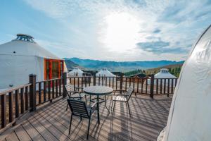 a deck with a table and chairs on a yurt at Blue Spot Resort in Yoliin Hural