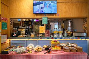 a counter with a table with food on it at Ostello Bello Lake Como in Como