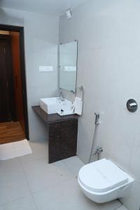 a bathroom with a white toilet and a sink at Hotel Sidh Vedantha in Patna +26 photos