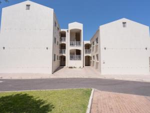 two white buildings on a street at Sunset Heights in Langebaan