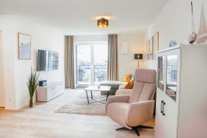 a living room with a couch and a chair at Küste33 34 in Tossens