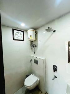 a bathroom with a toilet and a clock on the wall at Hotel Crystal Haven in New Delhi