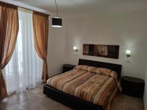 a bedroom with a bed and two windows at Domus Cassia in Cascia