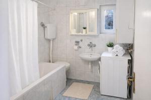 a bathroom with a tub and a sink and a toilet at Quiet & Cozy Apartment near Samobor - Terrace, Parking, Close to Zagreb & Tabor in Samobor +2 photos