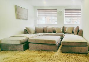 a living room with a large couch and ottoman at Spacious & Luxury 2BR Flat in Calverton in Calverton
