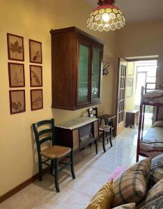 a living room with a table and chairs and a cabinet at Lo studio di Gabriella in Bolsena