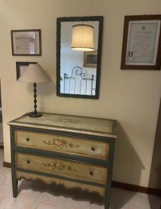 a dresser with a lamp and a mirror on a wall at Lo studio di Gabriella in Bolsena +8 photos