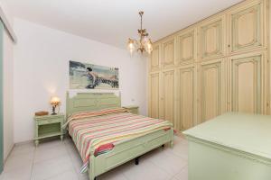 a bedroom with a green bed and a chandelier at Sale Marino - Goelba in Capoliveri