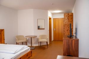 a bedroom with a bed and a table and chairs at Braugast Kreuz in Frastanz