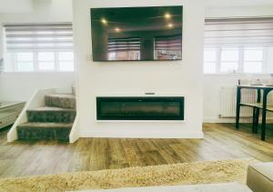 a living room with a fireplace and a staircase at Spacious & Luxury 2BR Flat in Calverton in Calverton