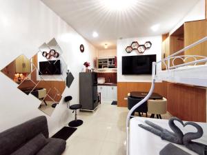 a living room with a couch and a kitchen at SNOW Studio Apartment - Near Clark International Airport in Mabalacat