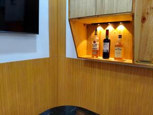 a cabinet with two bottles of wine in it at SNOW Studio Apartment - Near Clark International Airport in Mabalacat