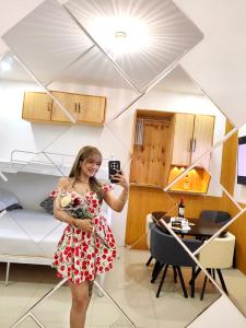 a woman taking a picture of herself in a room at SNOW Studio Apartment - Near Clark International Airport in Mabalacat