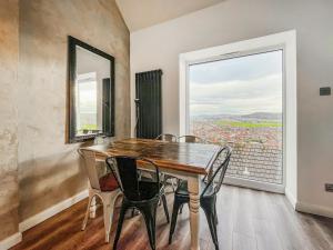 a dining room with a table and chairs and a window at Sea-Scape in Penrhyn Bay +15 photos