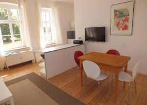 a room with a table and chairs and a kitchen at Rittergut Endorf in Endorf