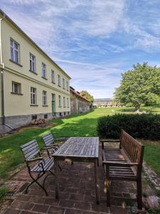 two benches and a picnic table in front of a building at Rittergut Endorf in Endorf