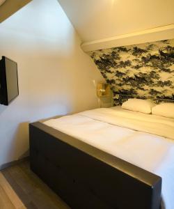a bedroom with a bed with a tv on the wall at Cottage du Lac Studio in Nivezé
