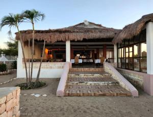 a house with a thatched roof and a staircase in front at Coconut Resort in Tuléar