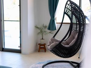 a black swinging chair in a room with a window at YUTO Ishigakijima in Ishigaki Island +94 photos