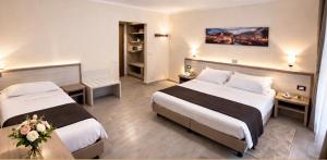 a hotel room with two beds and flowers in it at Hotel Adler in Milan