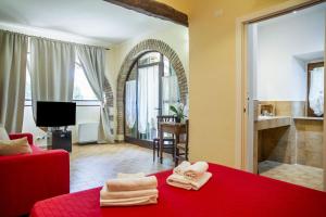 a room with a red bed with towels on it at El Molino Agriturismo in Fonteblanda
