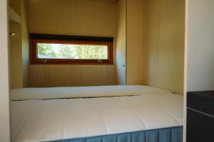 a bed in a room with a window at Vakantiepark De Klepperstee in Ouddorp