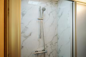 a shower in a bathroom with a marble wall at Vakantiepark De Klepperstee in Ouddorp