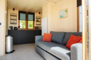 a living room with a couch and a kitchen at Vakantiepark De Klepperstee in Ouddorp +39 photos