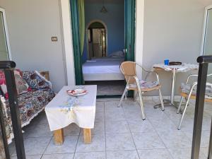 a room with a couch and a table and a bed at Ground floor economy studio in karmiris studios in Zakynthos