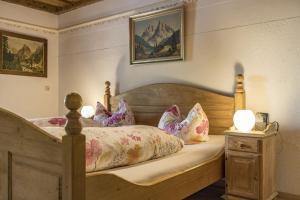 a bedroom with a wooden bed with pillows at Pension Lex in Bad Reichenhall