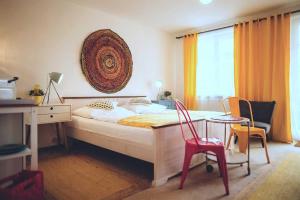 a bedroom with a bed and a desk and chairs at DAS STERN - Rooms - Self Check-In in Sankt Gilgen