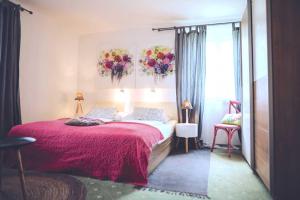 a bedroom with a large bed with a red blanket at DAS STERN - Rooms - Self Check-In in Sankt Gilgen