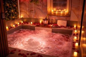 a jacuzzi tub with candles and roses in it at Rooms Vedran & AURUM Private Spa in Mostar +30 photos