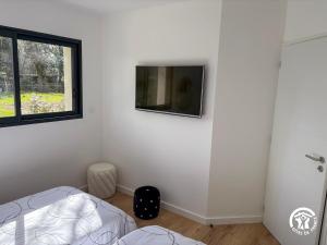 a bedroom with a bed and a tv on the wall at Villa des Oliviers in Flavin