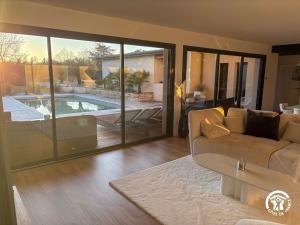 a living room with a couch and a swimming pool at Villa des Oliviers in Flavin