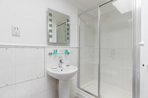 a white bathroom with a sink and a shower at Magnolia House - Beautiful Townhouse in Old Town Poole in Poole