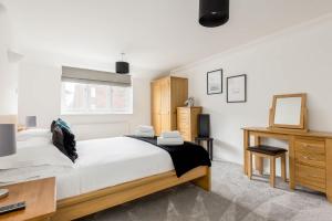 a bedroom with a bed and a desk and a mirror at Magnolia House - Beautiful Townhouse in Old Town Poole in Poole