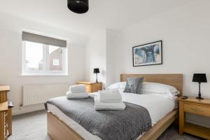 a bedroom with a bed with white sheets and a window at Magnolia House - Beautiful Townhouse in Old Town Poole in Poole +31 photos