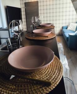 three plates on a counter with wine glasses on them at Cottage du Lac Studio in Nivezé