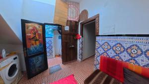 a small room with a door and a washing machine at Surfaces Hostel in Taghazout