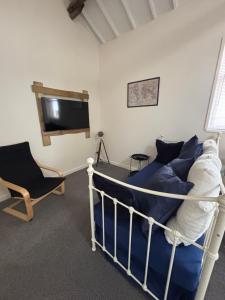 a bedroom with a bed and a tv and a chair at The old surgery in Rhymney