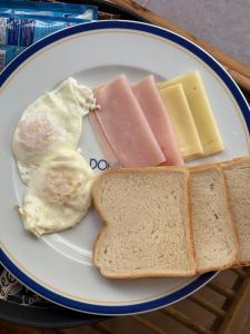 a plate with eggs ham and cheese and toast at MAG Palace Hotel in Bissau